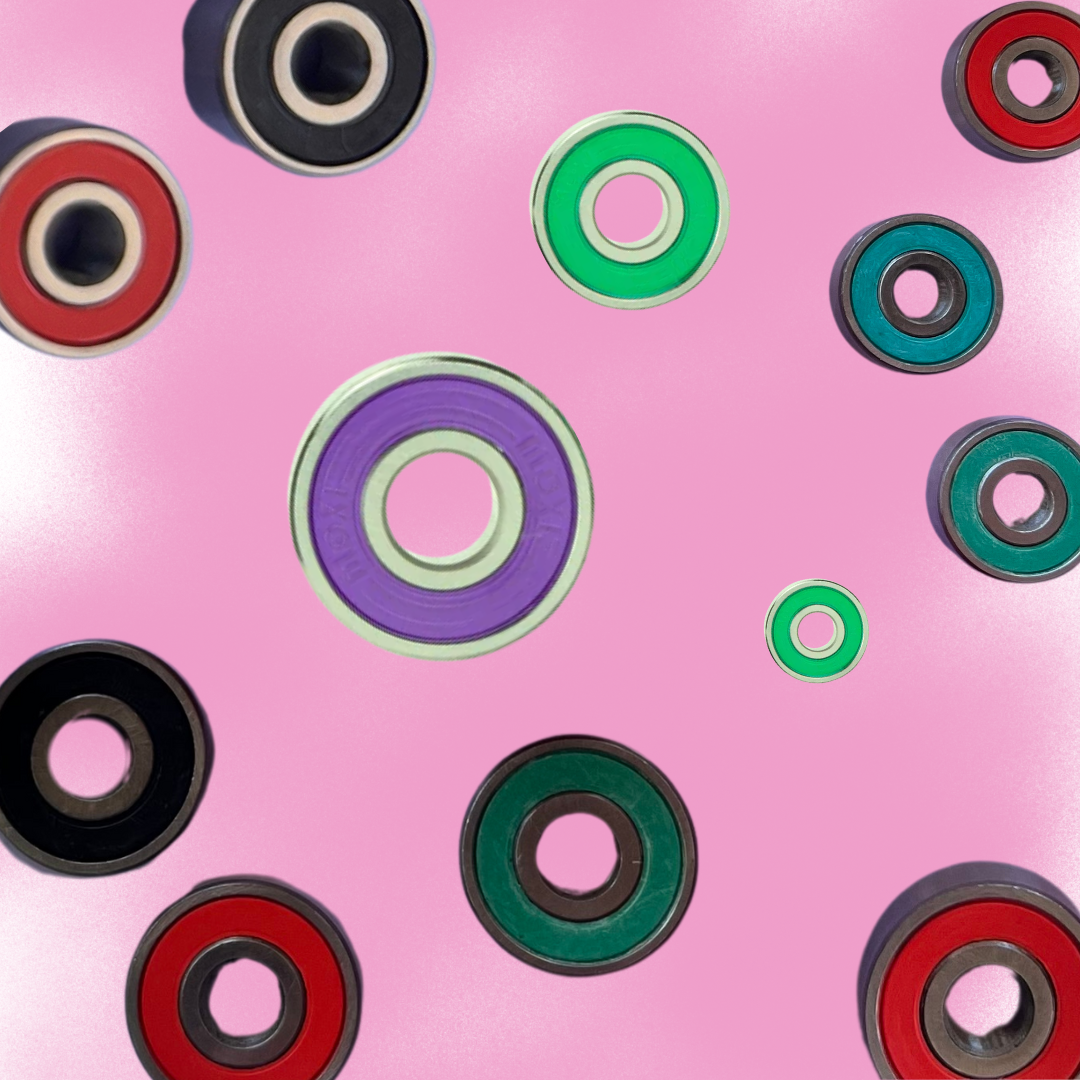 Roller skate bearings in different colours and sizes on a pastel pink spray paint texture background