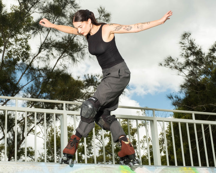 Roller skater Jade does a tabernacle slide on a metal mini ramp.