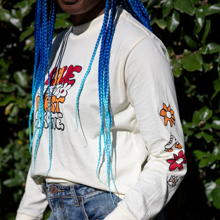Marcelle wears the cream RollerFit Love at First Skate long sleeve t-shirt with denim jeans.