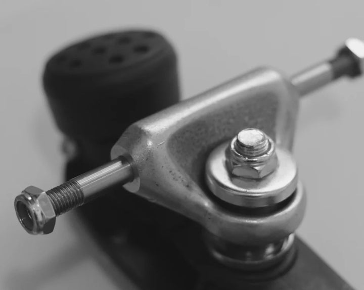 Close up of Magic Skate Goods 2.5 Inch Low Rider wide roller skate trucks in black and white