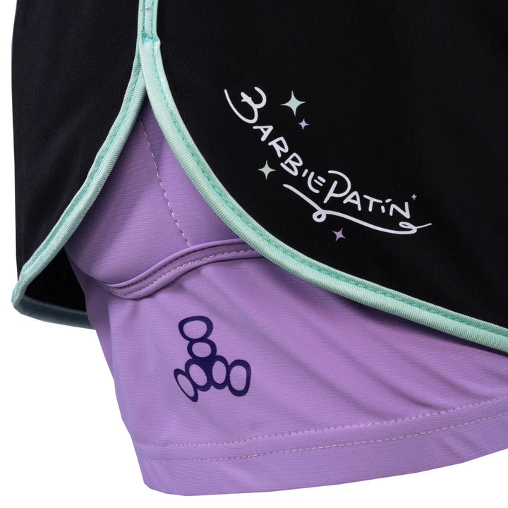 Close up view of Triple 8 Barbie Patin Bum Saver crash shorts - black athletic looking short with purple protection tights underneath