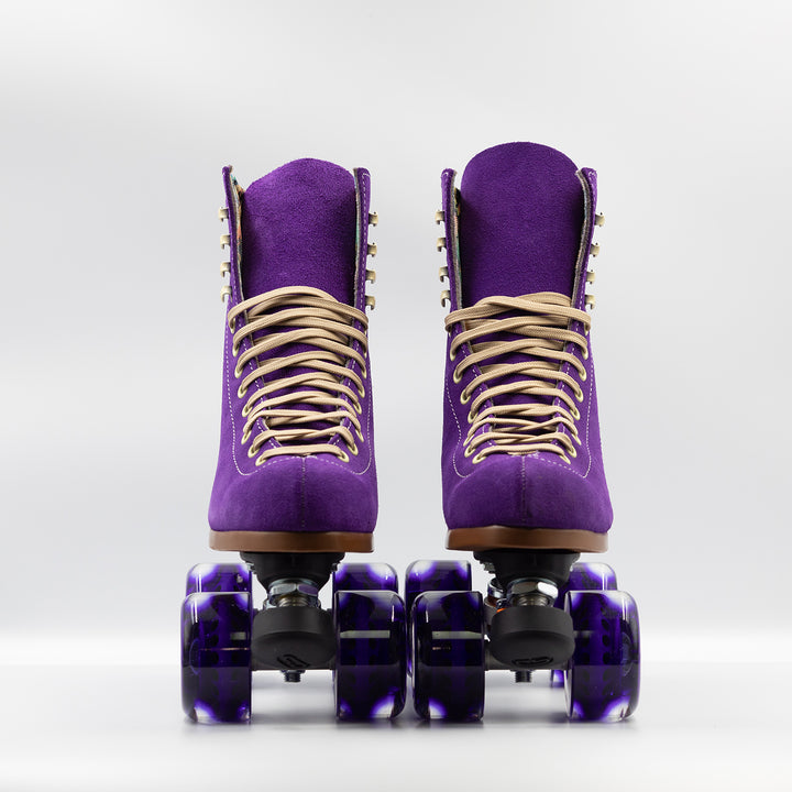 Moxi Roller Skates Lolly roller skates in Taffy purple with oyster laces and eyelets, tan sole, black plate and toe stop, matching purple wheels.