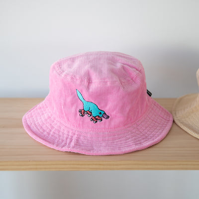 RollerFit pink corduroy bucket hat with blue skating platypus design.