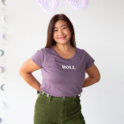 Jenn wears the RollerFit Roll mauve scoop neck t shirt with green pants.
