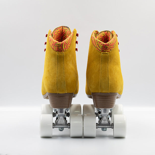 Chuffed Skates Birak roller skates with mustard yellow boots, coral laces, eyelets and logo embroidery, white wheels and toe stops.