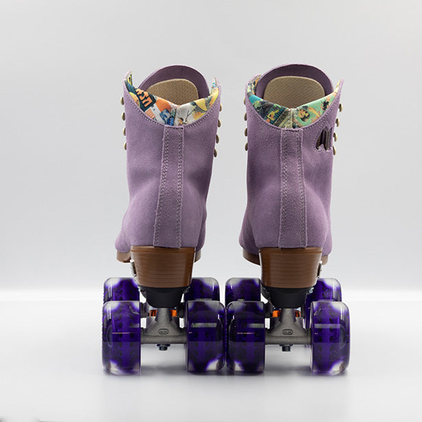 Moxi Roller Skates Lolly roller skates in Lilac with oyster laces and eyelets, tan sole, black plate and toe stop, matching purple wheels.