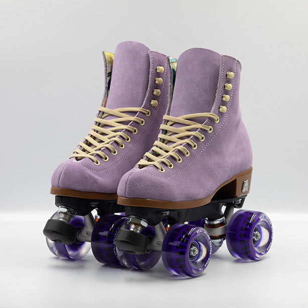 Moxi Roller Skates Lolly roller skates in Lilac with oyster laces and eyelets, tan sole, black plate and toe stop, matching purple wheels.
