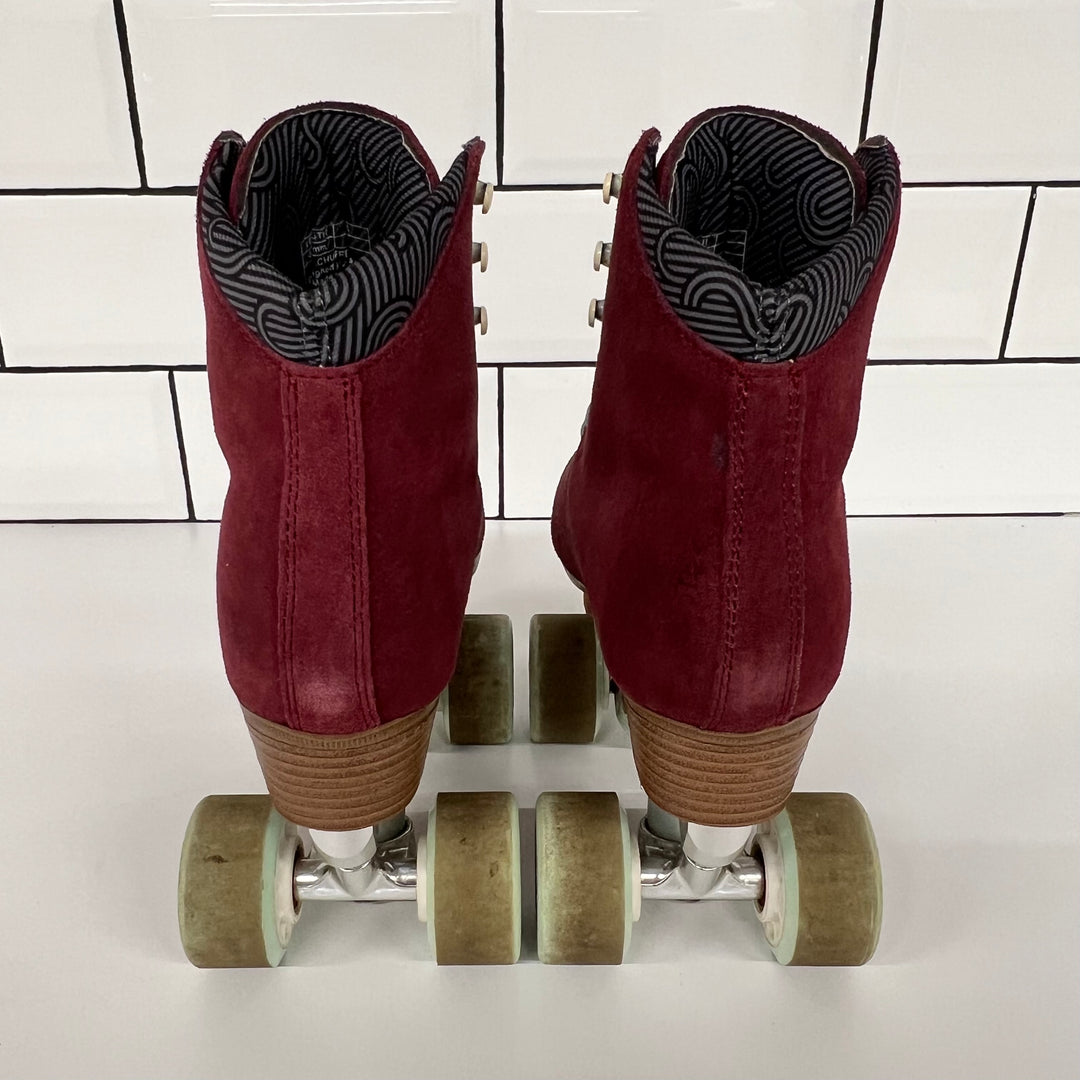 Pair of burgundy Chuffed custom setup roller skates with light blue laces on a white tiled background