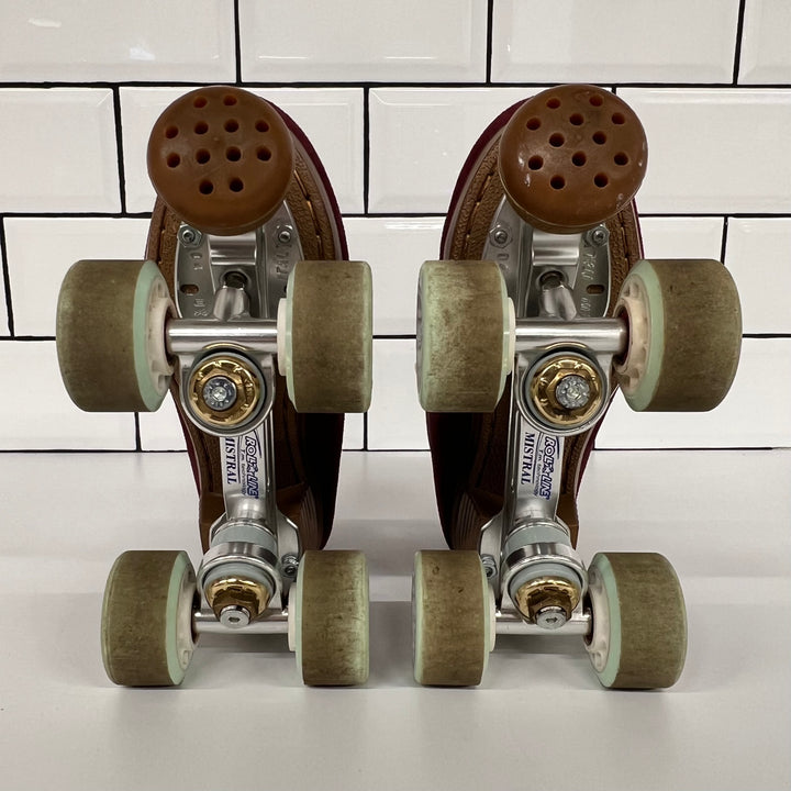 Pair of burgundy Chuffed custom setup roller skates with light blue laces on a white tiled background