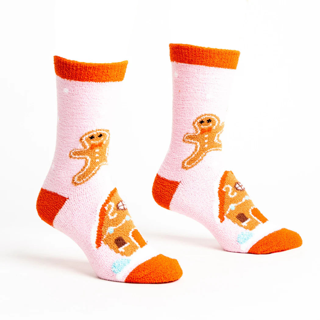 sock it to me fluffy no slip socks in pastel pink with an orange cuff featuring gingerbread people and house