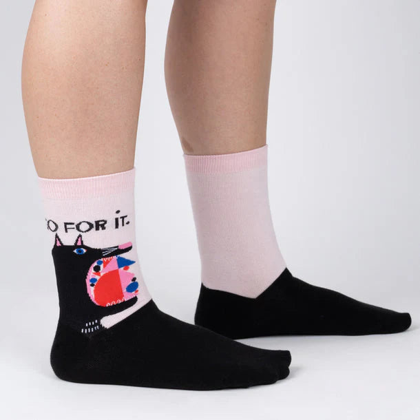 Sock It To Me crew sock with pale pink background and large black cartoon cat with shapes filling up it's wide mouth. Above the cat is the text "go for it"