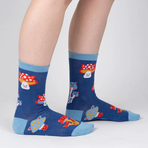 Navy blue crew socks with red, light blue and mustard cartoon mushrooms with cat faces for stools or caps.