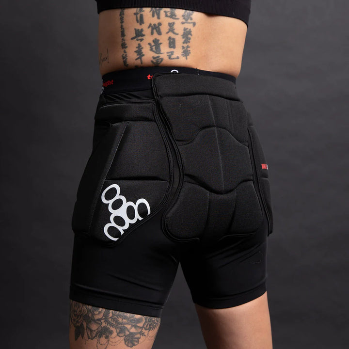 Skater with tattoos wearing Triple 8 Bum Saver 2 black padded protection shorts highlighting the generous butt coverage 