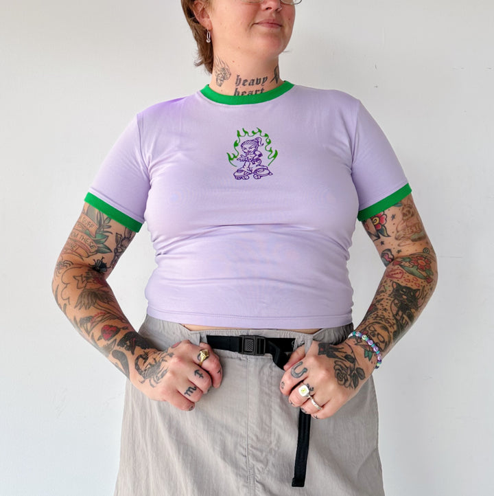 Linda wears the RollerFit 90's skater girl baby tee in purple with green ringer neck and sleeves.