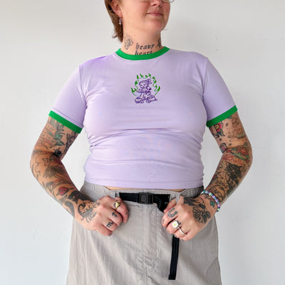 Linda wears the RollerFit 90's skater girl baby tee in purple with green ringer neck and sleeves.