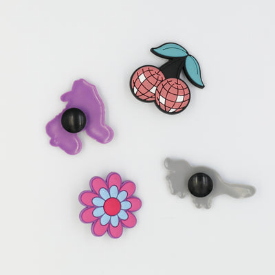 Croc charms designed for roller skaters. Four designs include disco cherries, RollerFit flower, classic skate and roller skating platypus.