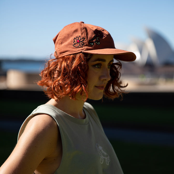 Demi has chin length red curly hair and is wearing the RollerFit Janky Skate Cap.