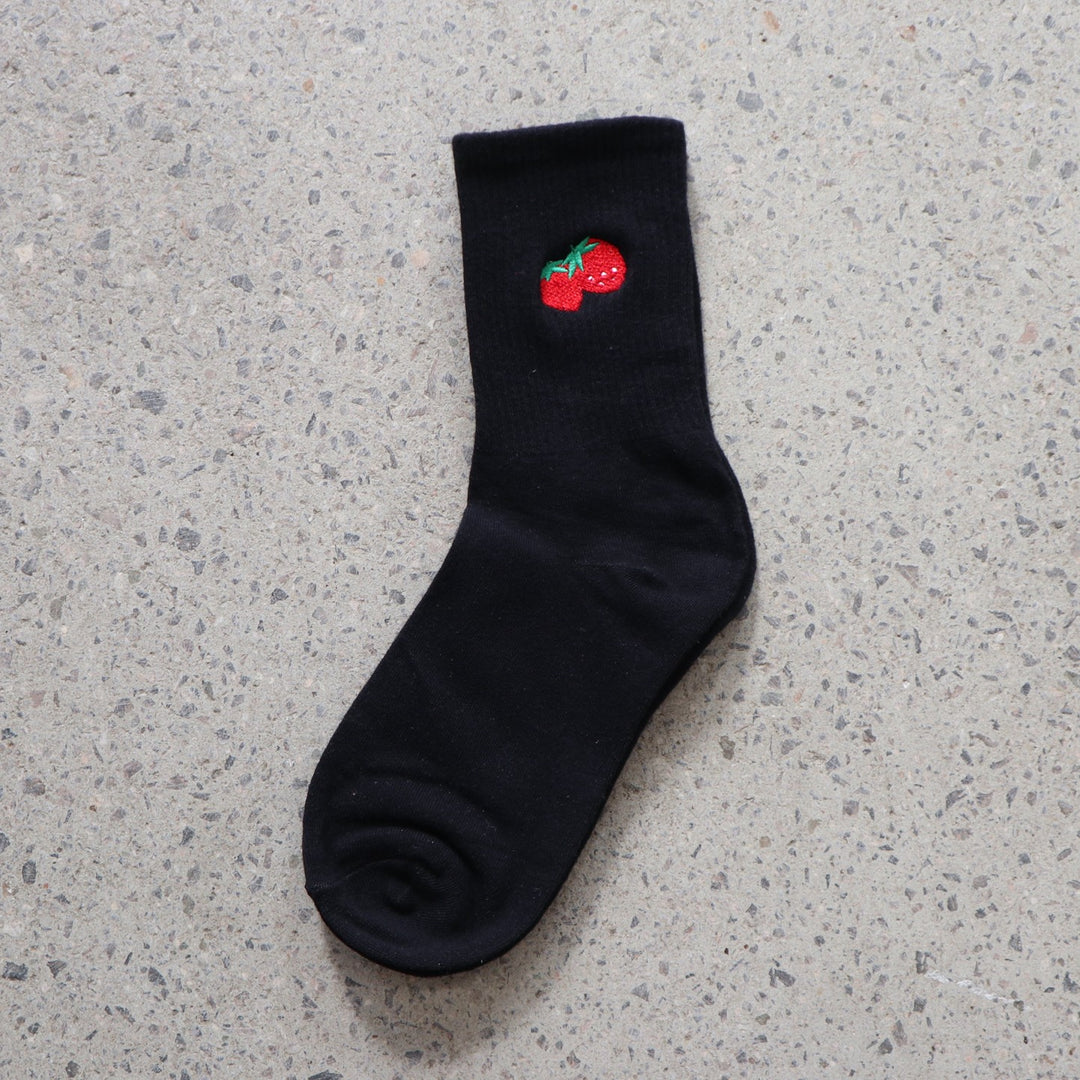Black RollerFit sock with red strawberry embroidered design on a gray surface
