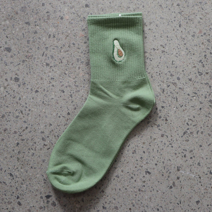 Green RollerFit sock with avocado embroidered design on a gray surface