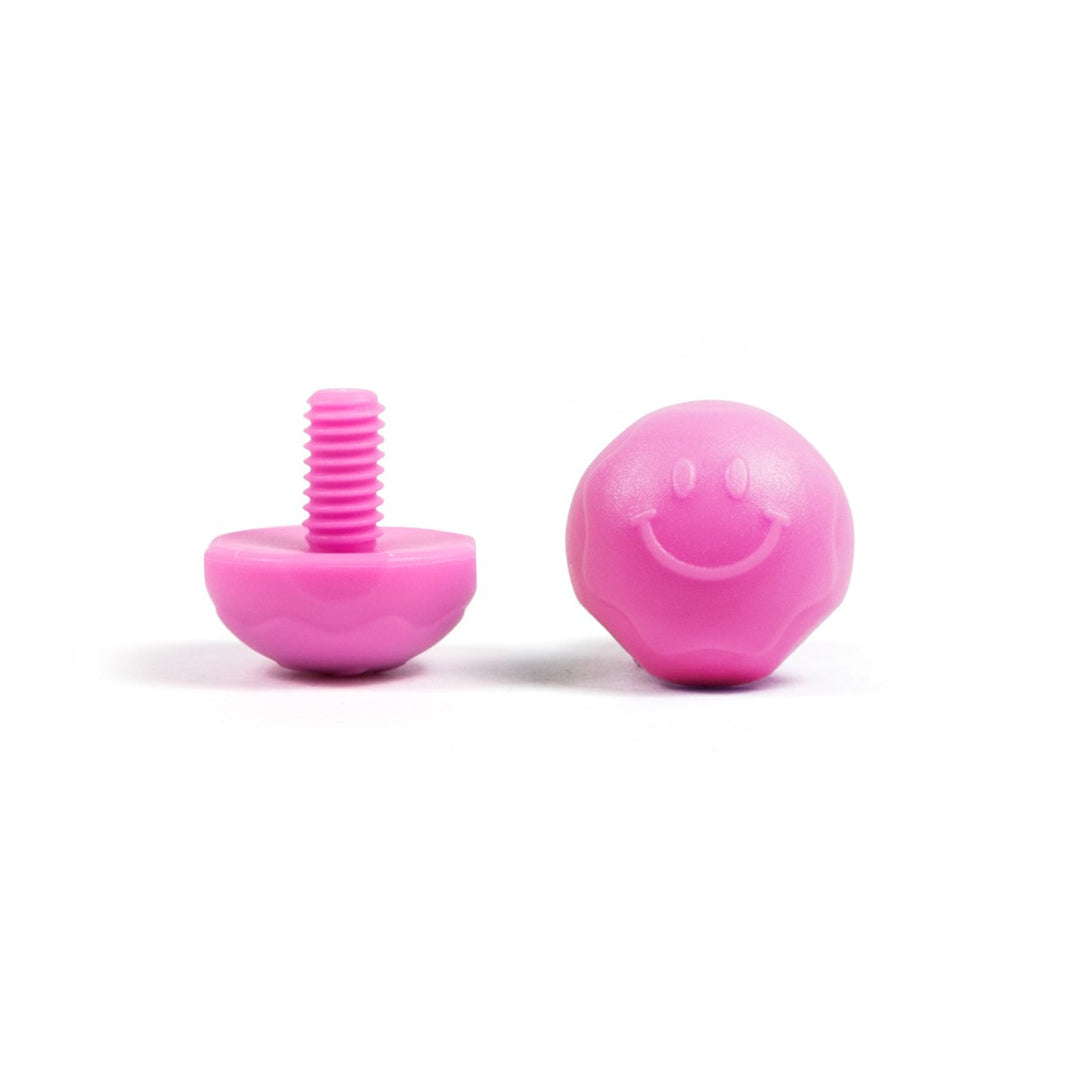 A pair of pink bolt-on toe plugs for roller skates, displayed on a plain background.