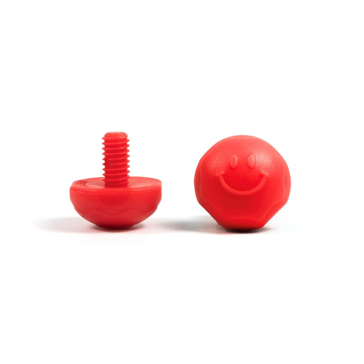 A pair of red bolt-on toe plugs for roller skates, displayed on a plain background.