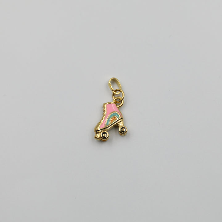 Gold charm shaped like a pink roller skate with rainbow details on a gray background