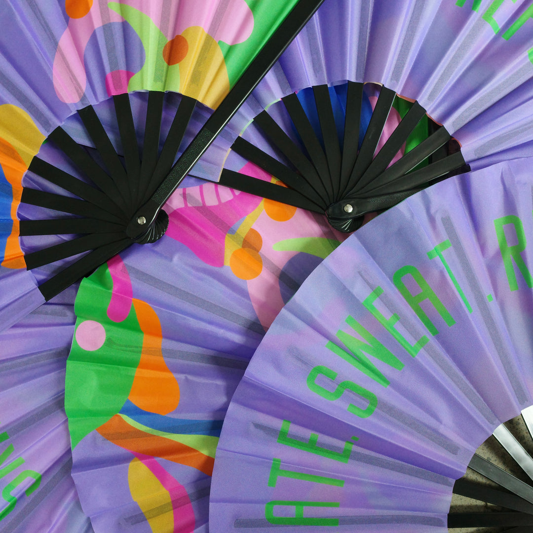 Pile of RollerFit Sweat Skate Repeat handheld fans with purple design