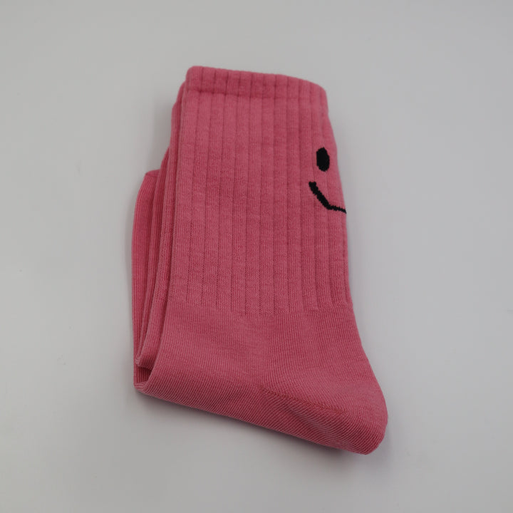 RollerFit ribbed crew socks with a smiley face eyes and mouth design above the heel: dark bubblegum pink with black smiley face