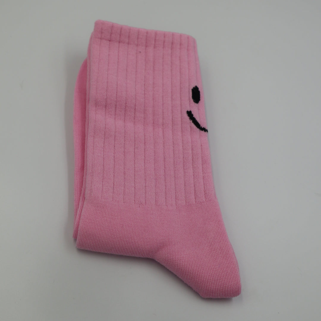 RollerFit ribbed crew socks with a smiley face eyes and mouth design above the heel: light pastel pink with black smiley face