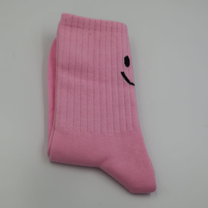 RollerFit ribbed crew socks with a smiley face eyes and mouth design above the heel: light pastel pink with black smiley face