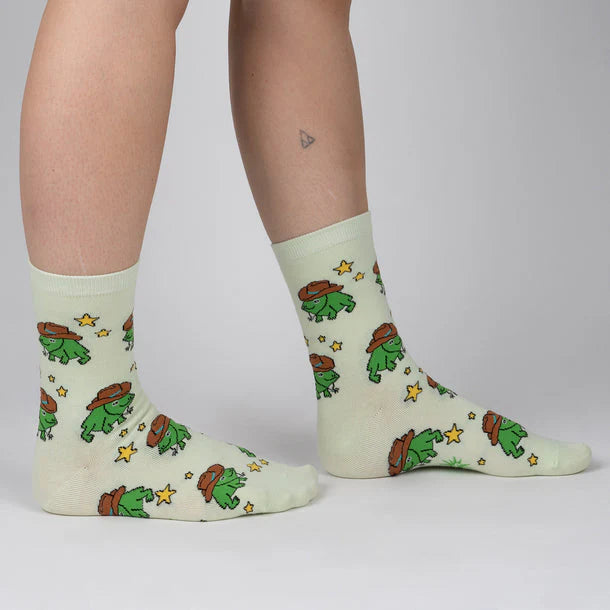 Light green socks with cartoon character design worn by a person on a plain background