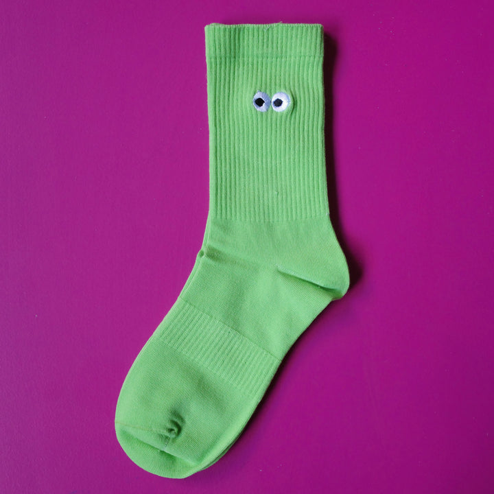 Lime green coloured crew sock with embroidered cartoon eyeball design