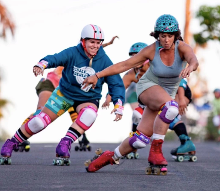 Pigeon and Estro bombing a hill on colourful roller skates wearing Moxi x 187 pads.