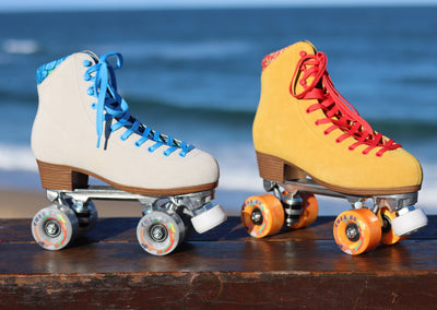 Chuffed Skates Bowzer (grey/blue) roller skate and Birak (mustard yellow/watermelon) roller skate with Cloudy and Sunny Chiller wheels respectively.
