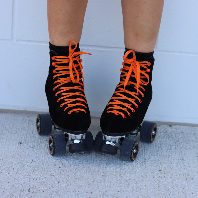 Chuffed Skates Fuegote roller skates with black suede boots, toe stops, wheels and orange laces, eyelets, logo embroidery and a piping hot flame lining.