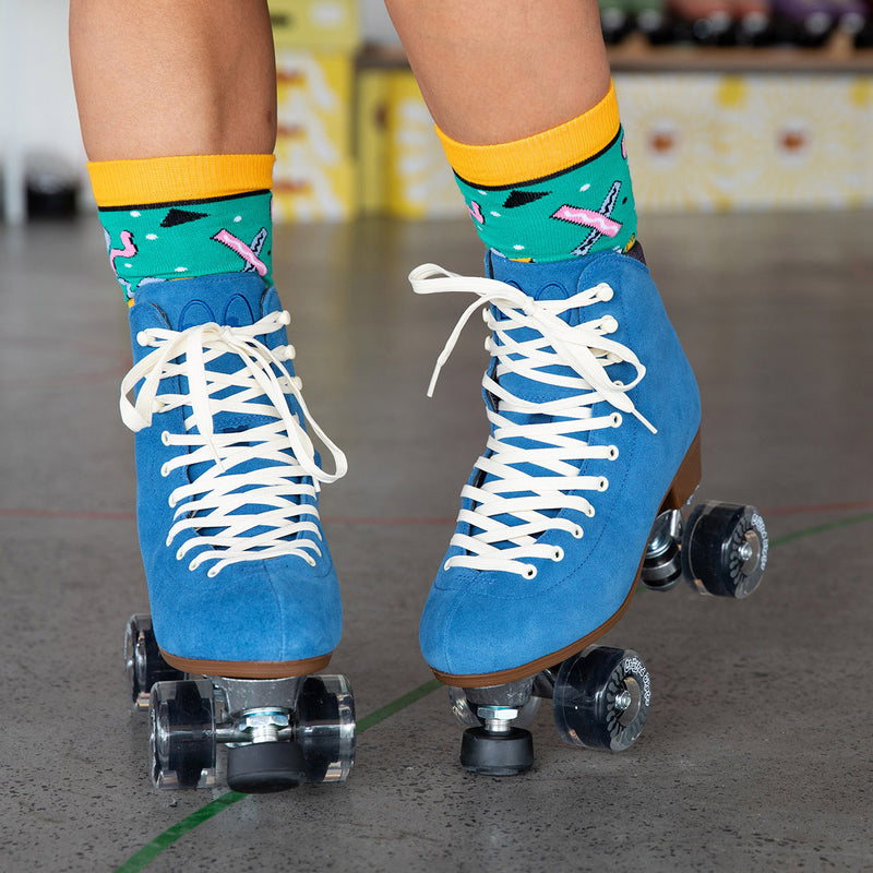 Jenn wears the Chuffed Skates Wanderer roller skates in classic blue with retro print green and yellow socks