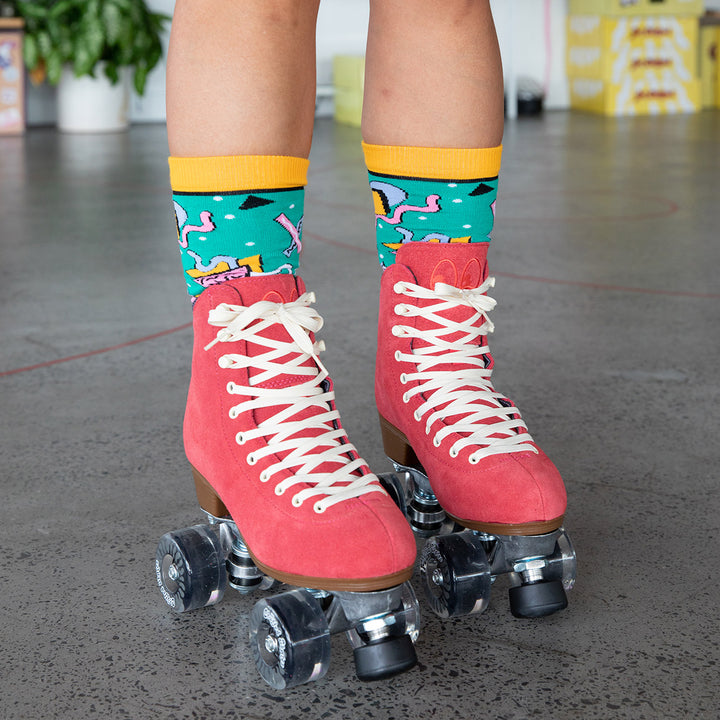 Jenn wears the Chuffed Skates Wanderer roller skates in watermelon red with retro print green and yellow socks
