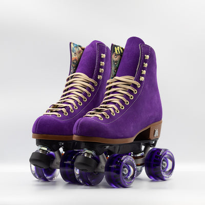 Moxi Roller Skates Lolly roller skates in Taffy purple with oyster laces and eyelets, tan sole, black plate and toe stop, matching purple wheels.
