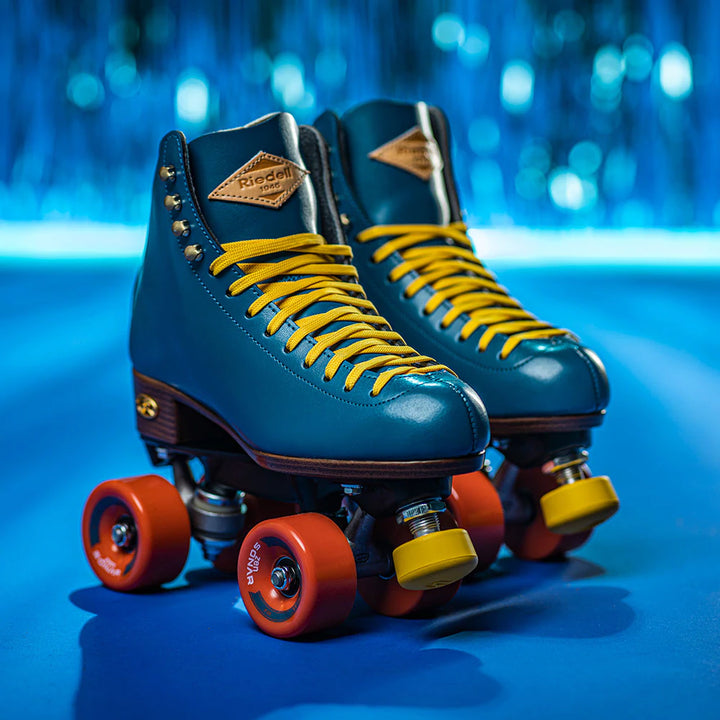 Riedell Crew roller skates in Ocean blue with yellow laces and toe stops, and orange wheels.