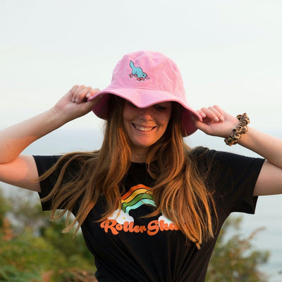 Stacey wears the RollerFit pink corduroy bucket hat with blue skating platypus design.