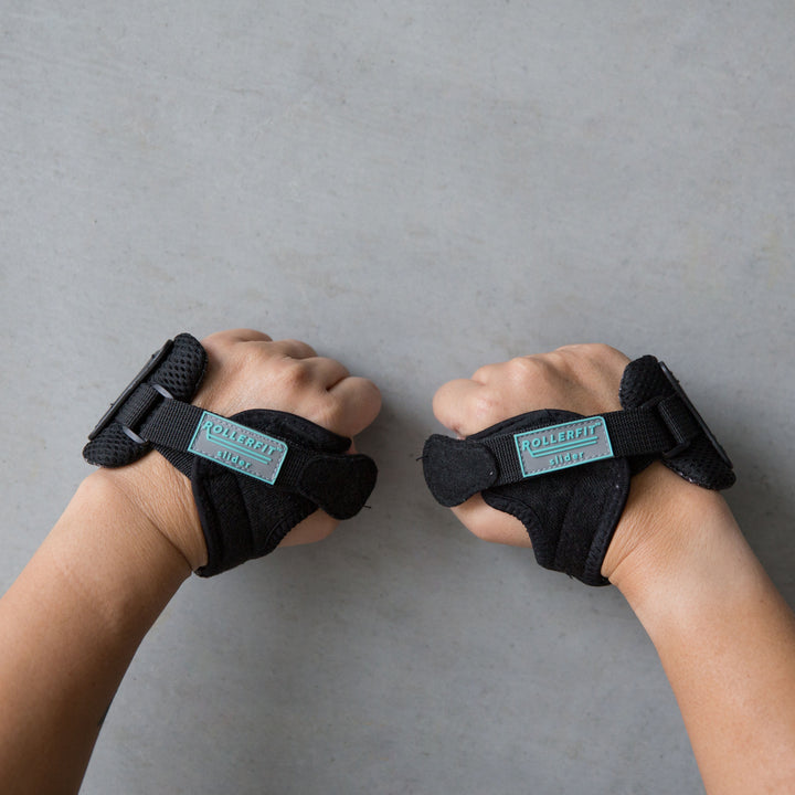 Rachel wears the RollerFit Palm Slider a light weight protective guard for your hands in black with blue accents.