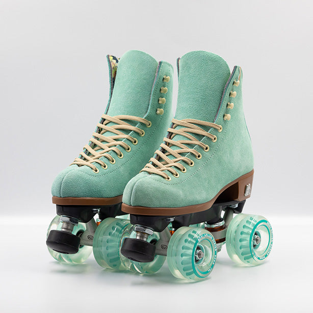 Moxi Roller Skates Lolly roller skates in Floss teal with oyster laces and eyelets, tan sole, black plate and toe stop, matching teal wheels.