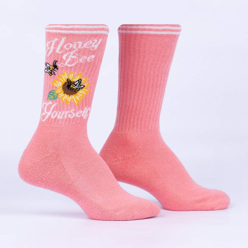 Pink socks with sunflower and bee design and white text saying "honey bee yourself".