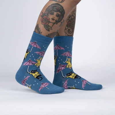 Navy blue socks with cartoon cats and dogs in raincoats with umbrellas as rain drops down.